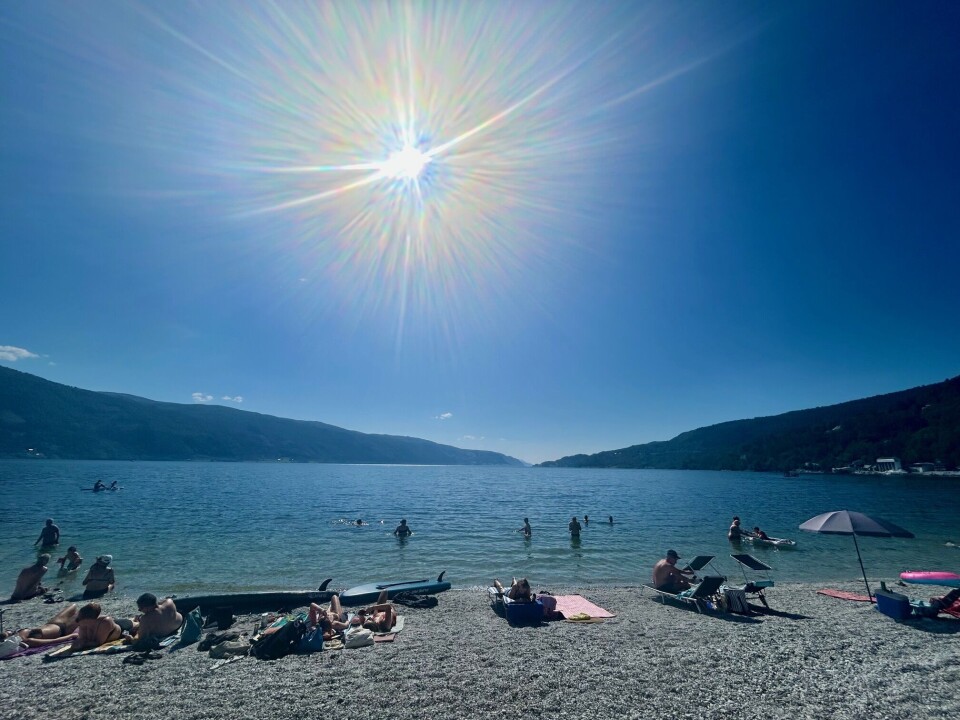 Sola steikte godt på Kalkstranda på Glærum denne torsdagen. Sol som skinner over fjord og blå himmel, folk på stranda