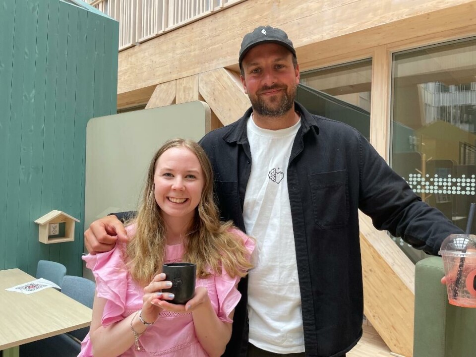 Podkastlydteknikker Gine Sæterbø fikk gleden av å kjøpe den første BROR-kaffekoppen av Even Karpuz i BROR Mental Helse. Smilende ungdom med langt, bølgete hår holder en kopp. En mann står og smiler ved siden av henne og holder en hånd på skulderen hennes.
