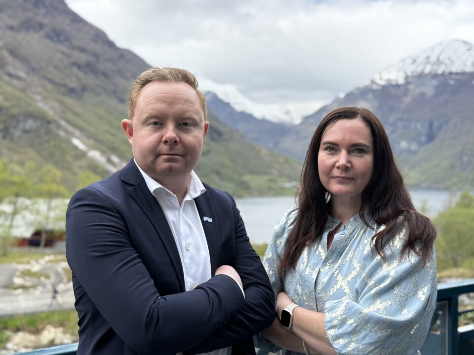 Carl-Henrik Moltumyr og Monica Molvær. En mann og ei dame som står ved siden av hverandre og ser litt strenge ut. Fjord og fjell i bakgrunnen.