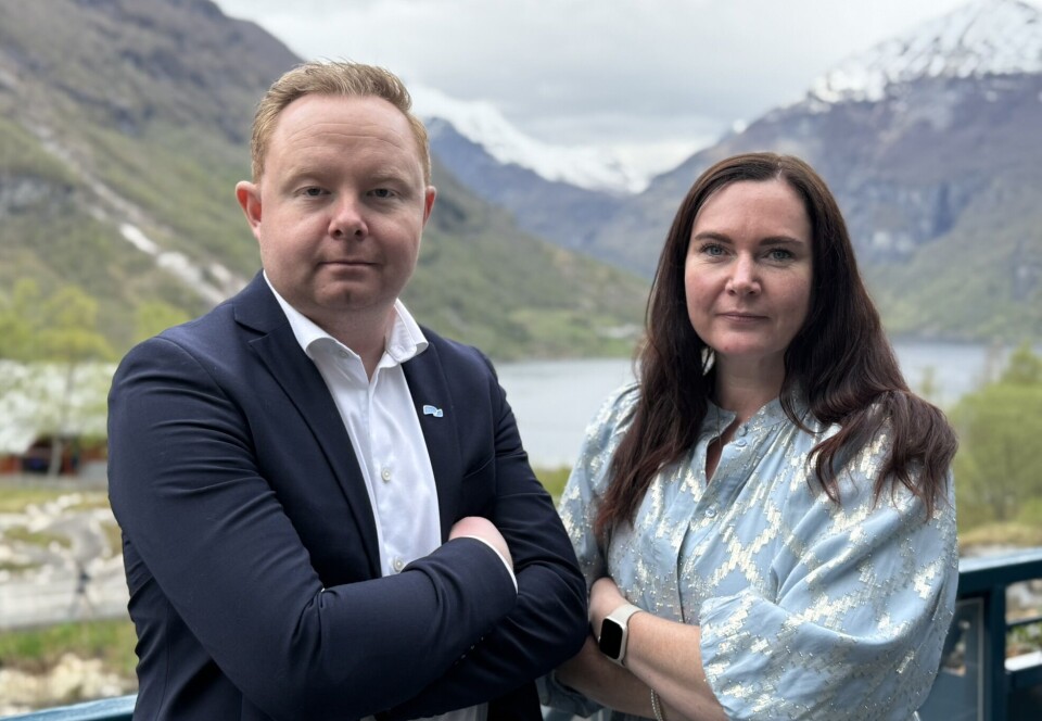 Carl-Henrik Moltumyr og Monica Molvær. En mann og ei dame som står ved siden av hverandre og ser litt strenge ut. Fjord og fjell i bakgrunnen.