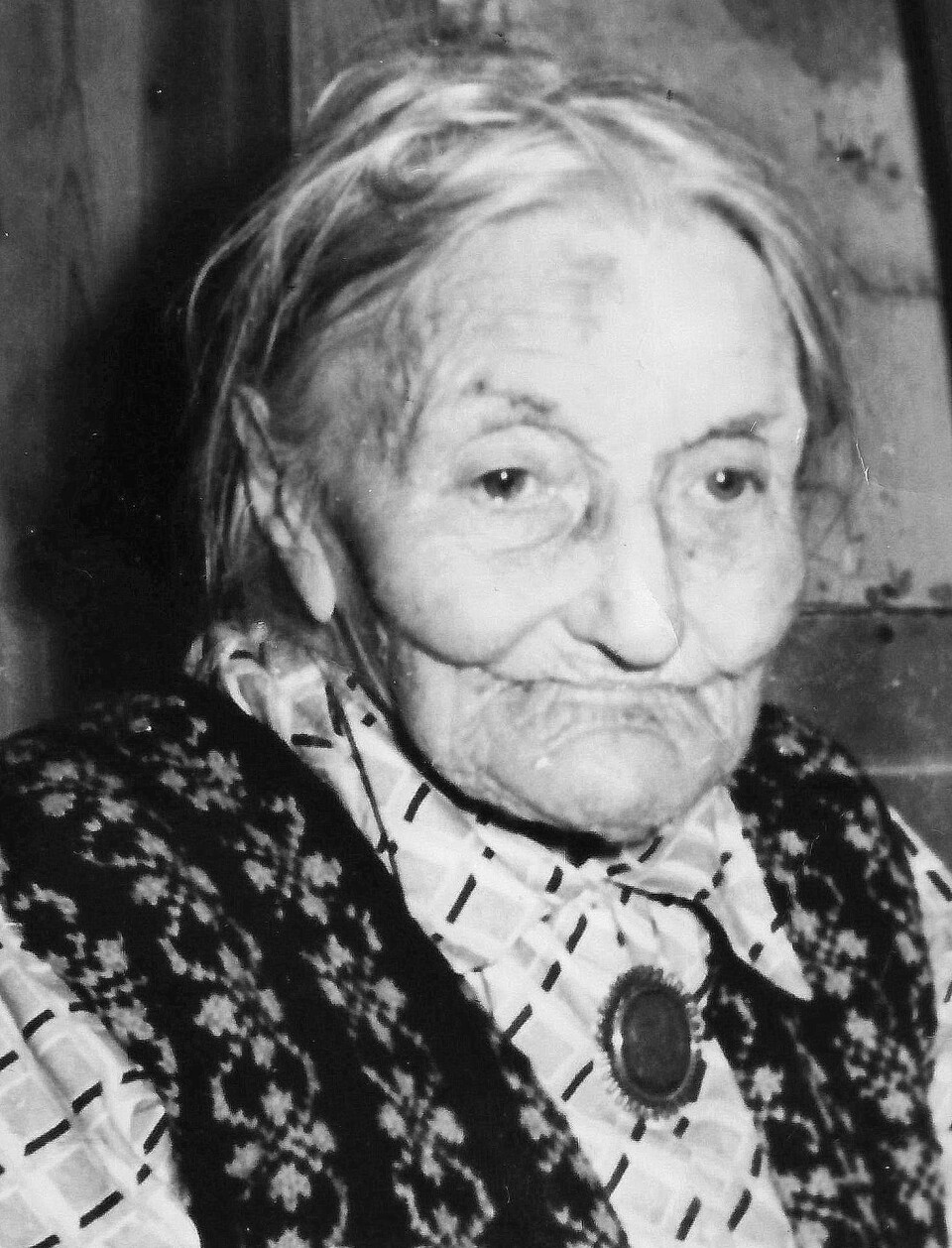 Guro på sine gamle dagar – etter eit langt og innhaldsrikt, men slitsamt liv. Et gammelt svart/hvitt-portrettbilde av ei svært gammel dame, pynta med bluse og strikkavest. Hun ser alvorlig og tenksom ut.