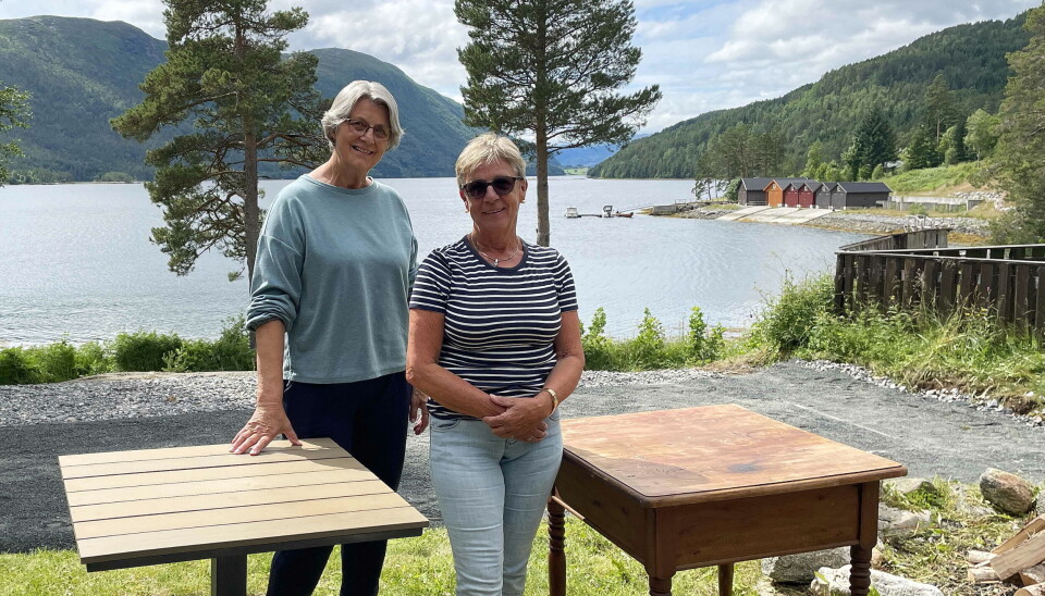 Klokkar Randi og soknerådsleiar Eva inviterer også i år til utegudsteneste ved vakre Åsskardfjorden. to damer mellom to bord ute