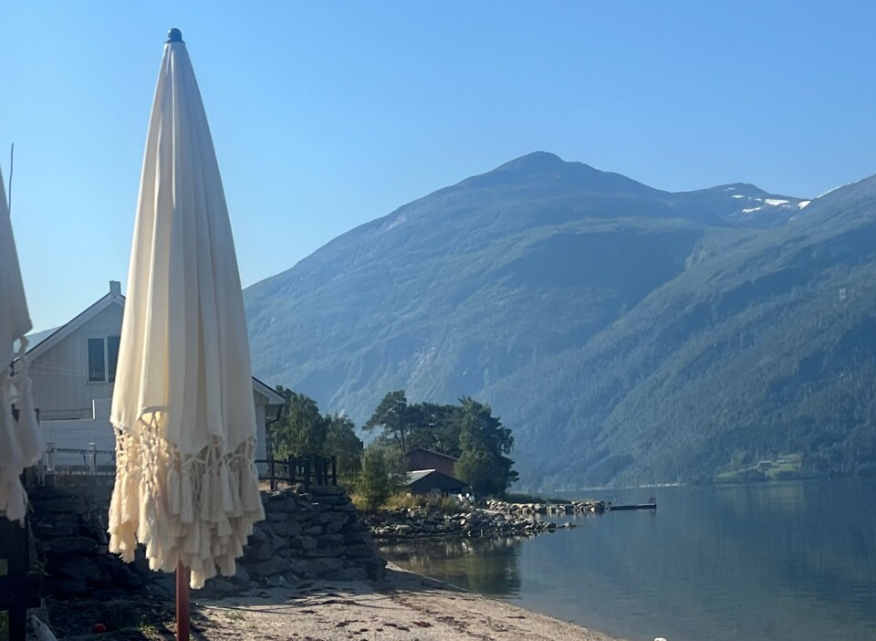 God morgen fra Nordvik parasoll med strand og fjell bak