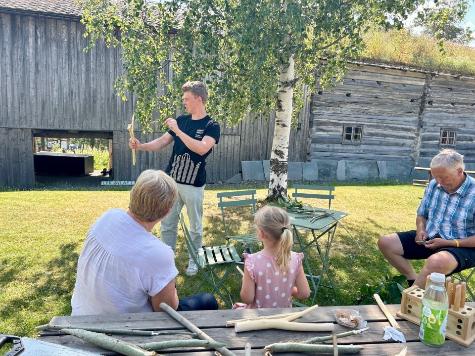 Erik fra museet demonstrerer bruk av sprettert. Jente og besteforeldre følger med på at mannlig ansatt demonstrerer bruk av sprettert
