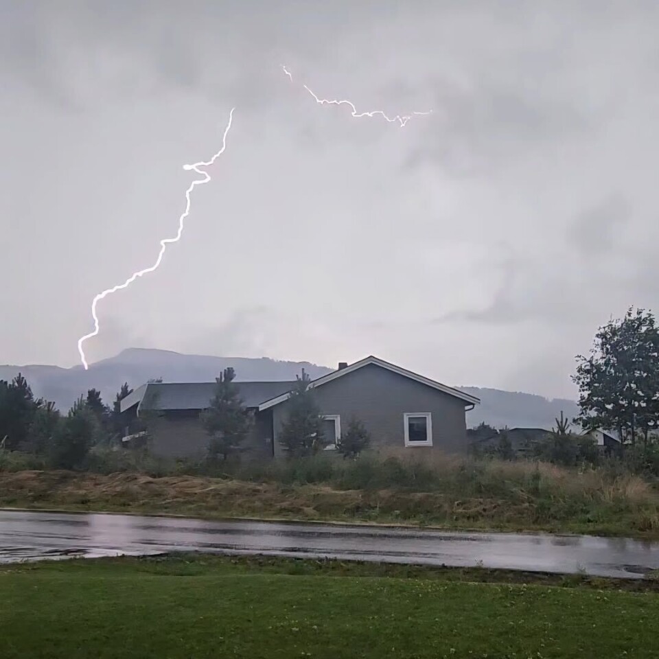 Heftig vær.. ⛈️🌩 Et kraftig lyn som slår ned bak en fjelltopp. Et vanlig bolighus i forgrunnen.