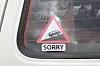 Klistremerke med teksten, sorry, på bakvinduet til en gammel transporter.