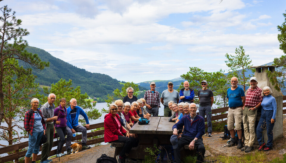 Alle samlet på rasteplass med vakker utsikt Mennesker i turklær på rasteplass med utsikt over fjorden