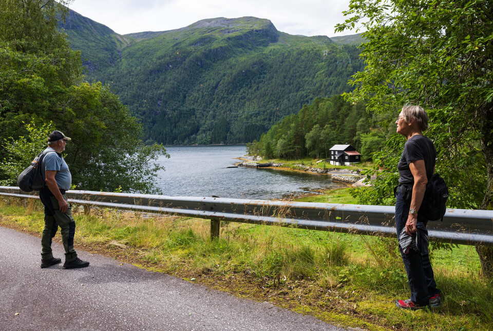 Tilbake i Svinvika To mennesker i turklær ved vei med autovern, fjord i bakgrunnen