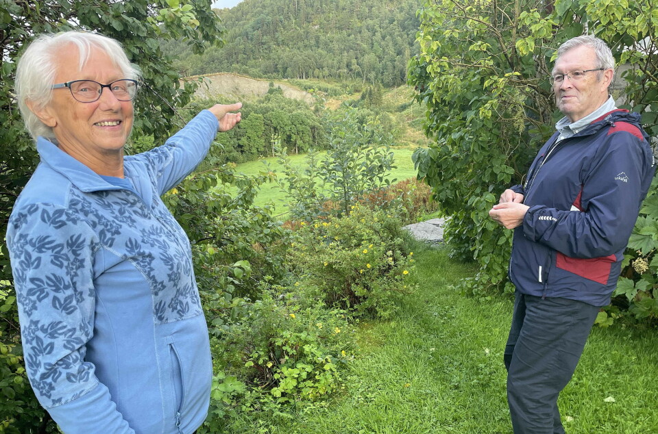 - Det heiter at ein to hundre år gammel sølvskatt ligg borti lia her ein stad, seier Annbjørg Engset i Dreyerstua. Bernt Bøe lovar meir om dette på museet søndag. Dame og mann i en hage, damen peker mot skogen