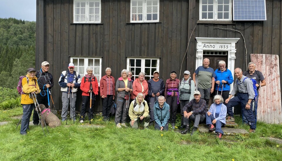 Stavgang til Leikaren mennesker oppstilt foran brun hytte