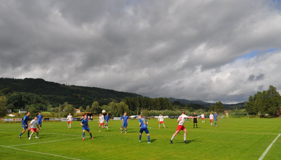 fotballspillere på bane med overskyet vær