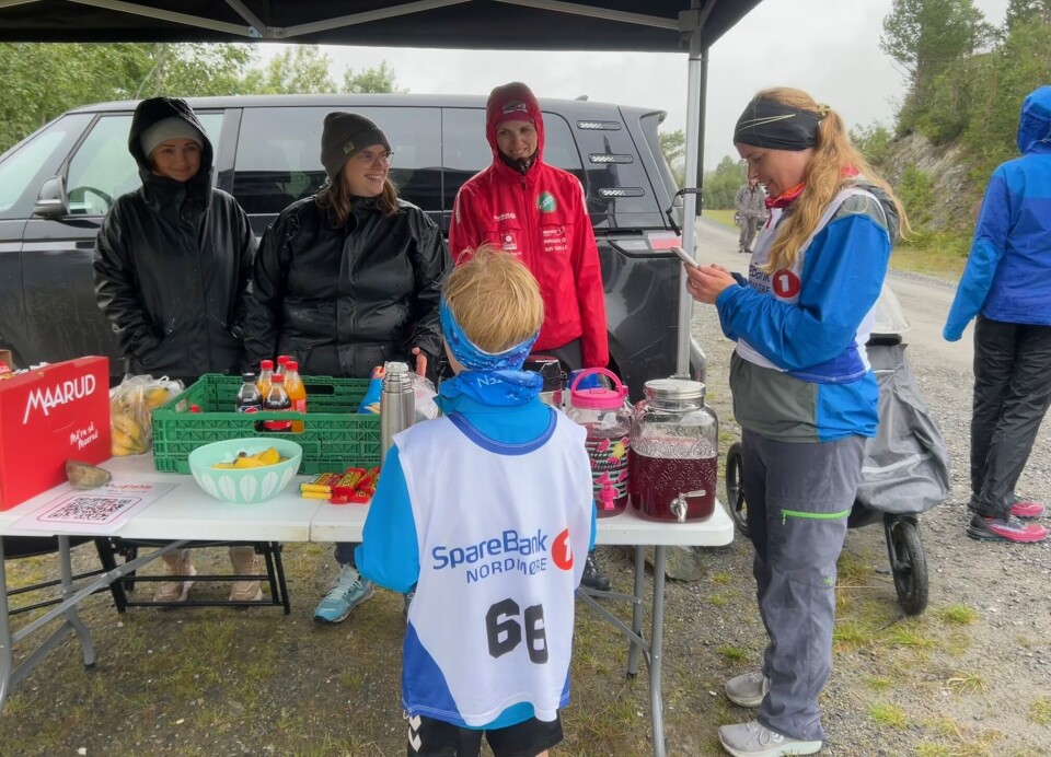 Blide ØSIL-damer som serverer saft og noko attåt i den friske vinden etter målgang. Damer med regntøy i kiosken