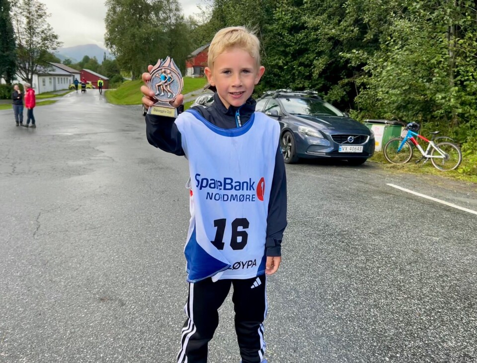 Mikkel Bolme er godt fornøyd med premie etter endt løp Gutt som holder frem en pokal med løpere på