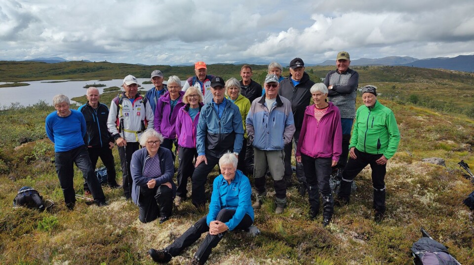 Tirsdagstur til Salvatnet, Holmvatnet og Holmvassetra Ei gruppe på omtrent 20 turkledde personer oppstilt for fotografering på fjellet. Sommervær og skyer på himmelen.