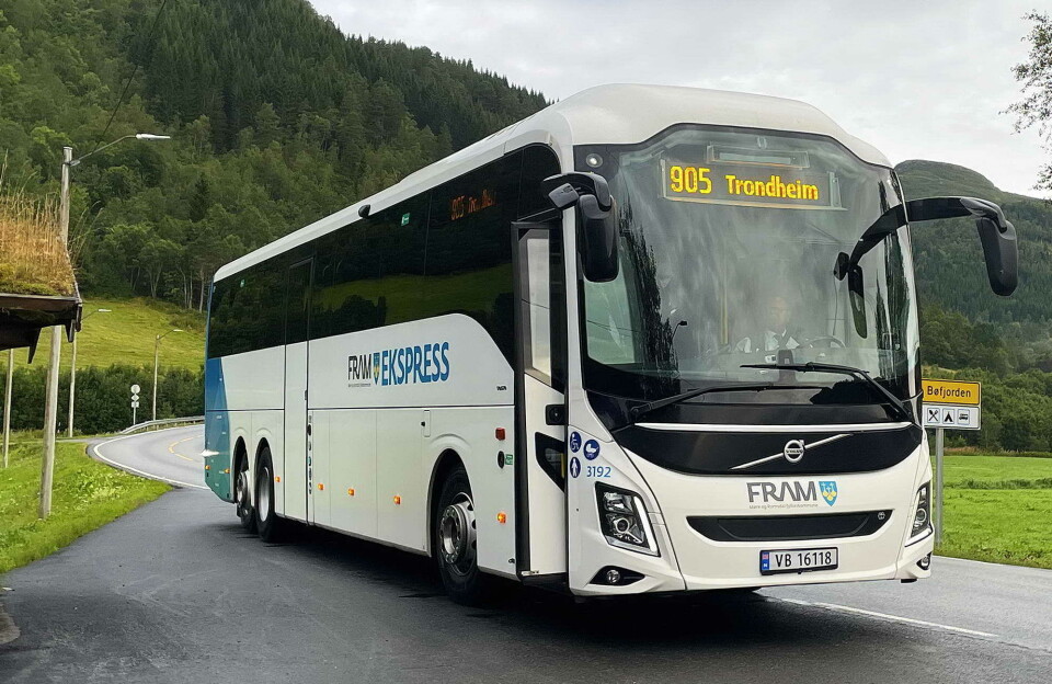 Still going: Bussen har bunde oss saman i over hundre år. Her er det anløp i Settemsdalen på tur til Trondheim måndag denne veka. Foto Bernt Bøe Hvit buss med påskrift FRAM Express, skiltet med 905 Trondheim. På vei ut av asfaltert busslomme med busskur og med grønne jorder og grønn skogkledd ås i bakgrunnen. Skilt med Bøfjorden skimtes til høyre for bussen.