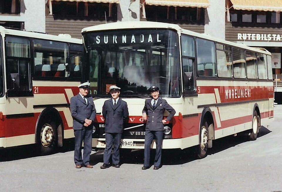 Tidleg på 1970-talet flytta billaget frå Øra til nystasjonen. Her i 1982 ser vi Erling Sæthervik (t. v.), Sigmund Gravvold og Fredleiv Bolme. Tre menn i blå uniformer og skyggelue foran to røde og hvite busser med påskrift Mørelinjen. På den ene bussen står det Surnadal i fronten oppe.De står foran et brunt og hvitt bygg med skilt. Rutebilstasjon.