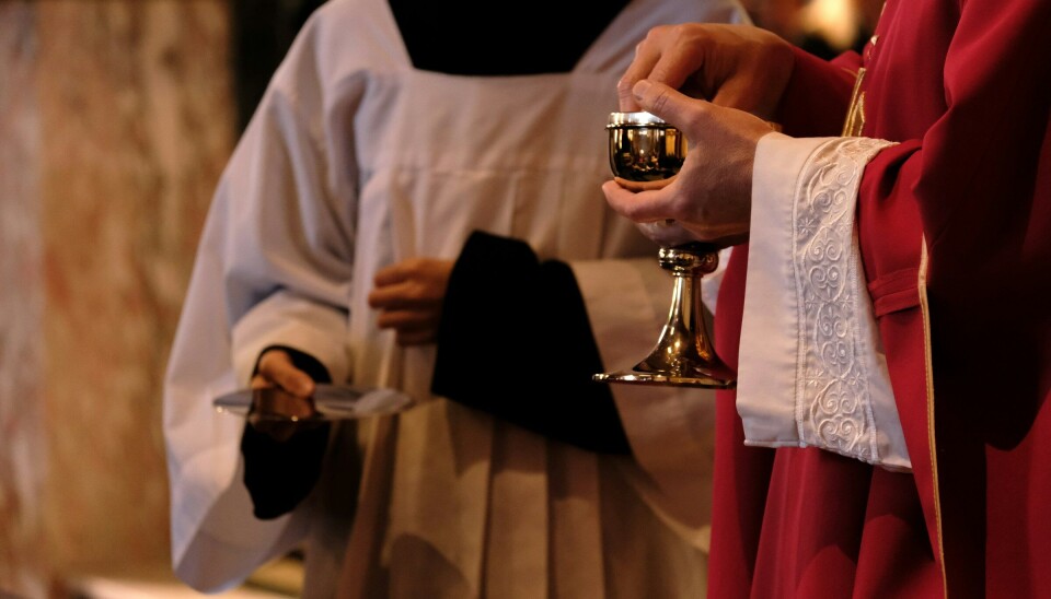 Katolsk messe i Surnadal Katolske prester som holder en kalk og et fat.