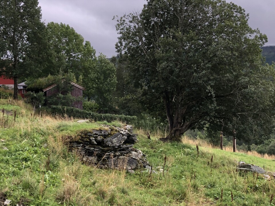 Låvekloppa i Utistu Yttgarden. Murrestene av ei gammel låvebru. Grått og vått sommervær