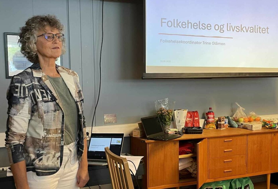Trine Glåmen tala om einsemd og korleis det kan påverke livskvaliteten vår. Ei dame med krøllete halvlangt grått hår og briller står og snakker til en forsamling. Bak henne er et lerret med tekst på.