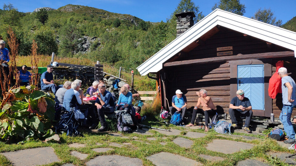 En pause ved Vollasetra gjorde godt før neste etappe til toppen. Mennesker som sitter å spiser.