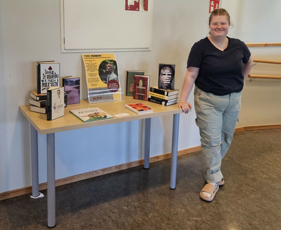 Biblioteksjef Ida Kaspara Hyttebakk med Renberg utstillingen Dame står ved siden av et bord med arrangerte bøker