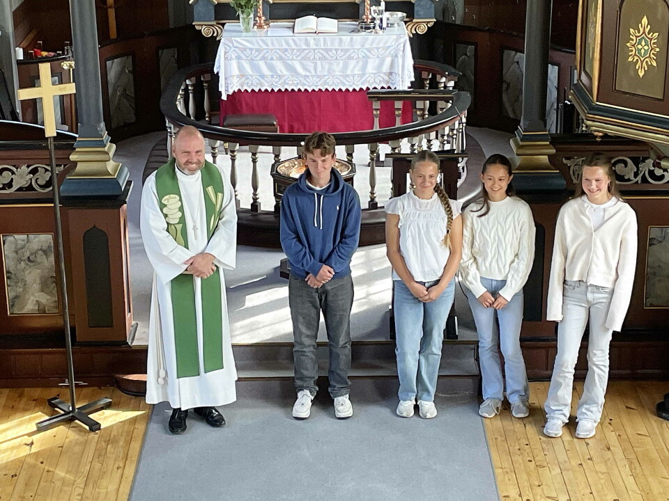 Ein glad prost Vidar Wilhelmsen Rygh presenterte dei nye konfirmantane i Åsskard: Sindre, Ingrid, Mathilde og Vår. En prest og fire tenåringer som står oppstilt i koret i ei kirke.