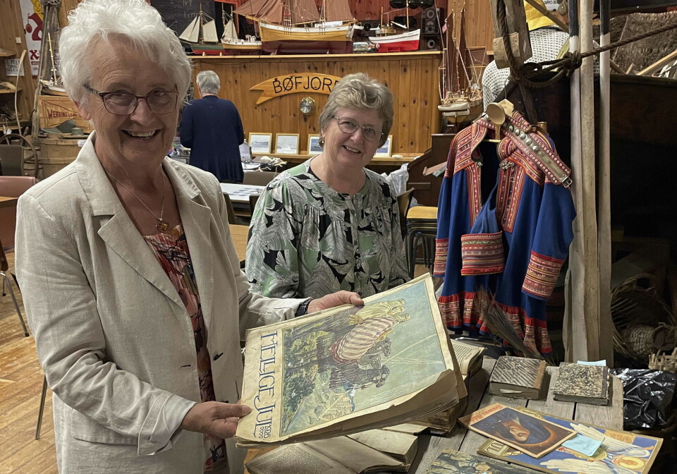 Dreyerstua hadde mykje fint på utstillinga, konstaterer Mali Settem (bak) og Inger Marie Paulsen - sistnemnte med Misjonsselskapets «Hellige Jul» frå 1926. To voksne damer i et museumslokale. den ene holder fram et veldig gammelt bland/magasin.