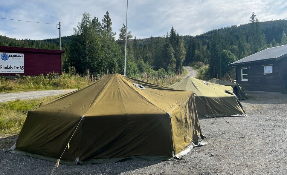 Det har ikke vært behov for ovn i åttemannsteltene denne uka. To militære åttemannstelt slått opp på en parkeringsplass. Sol og sommer.
