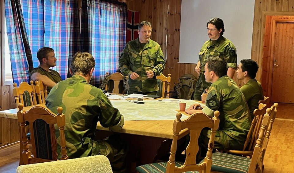 Møte i kommandørommet. Seks menn i miitæruniform rundt et bord.