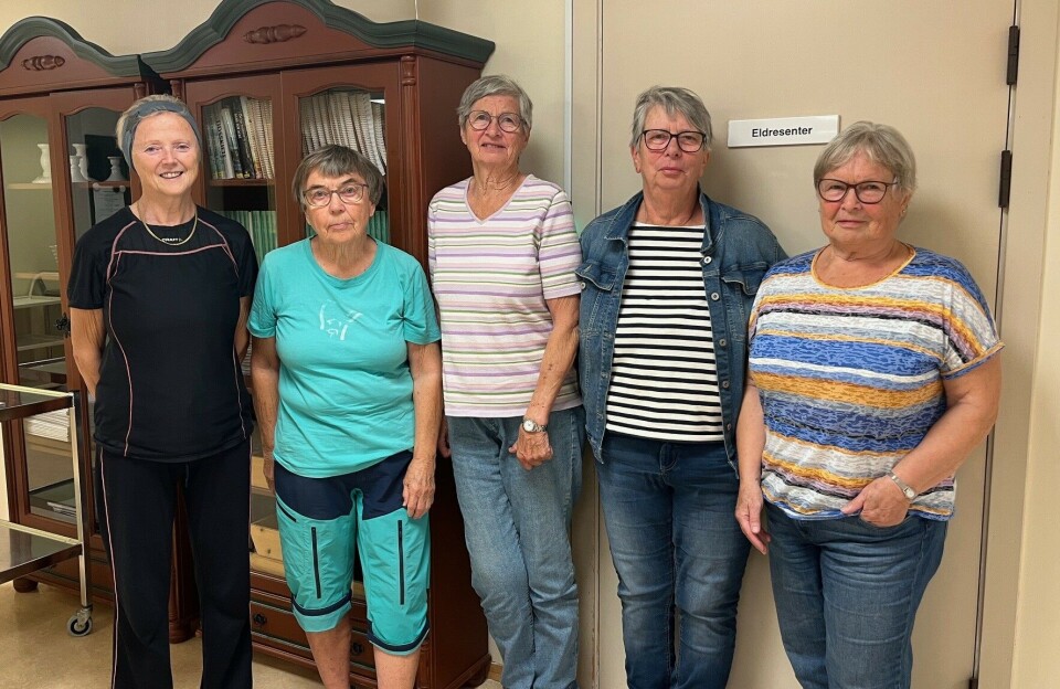 F.v. Kristine Ree, Helene Marie Nergård, Lisbet Stenbro, Anne-Lise Forsberg og Ingeborg Landsem er alle aktive brukere av Eldresenteret i Rindal. De kan ikke forstå hvorfor kommunen ønsker å endre på noe som fungerer optimalt. Fem damer oppstilt for fotografering foran ei dør, innendørs.