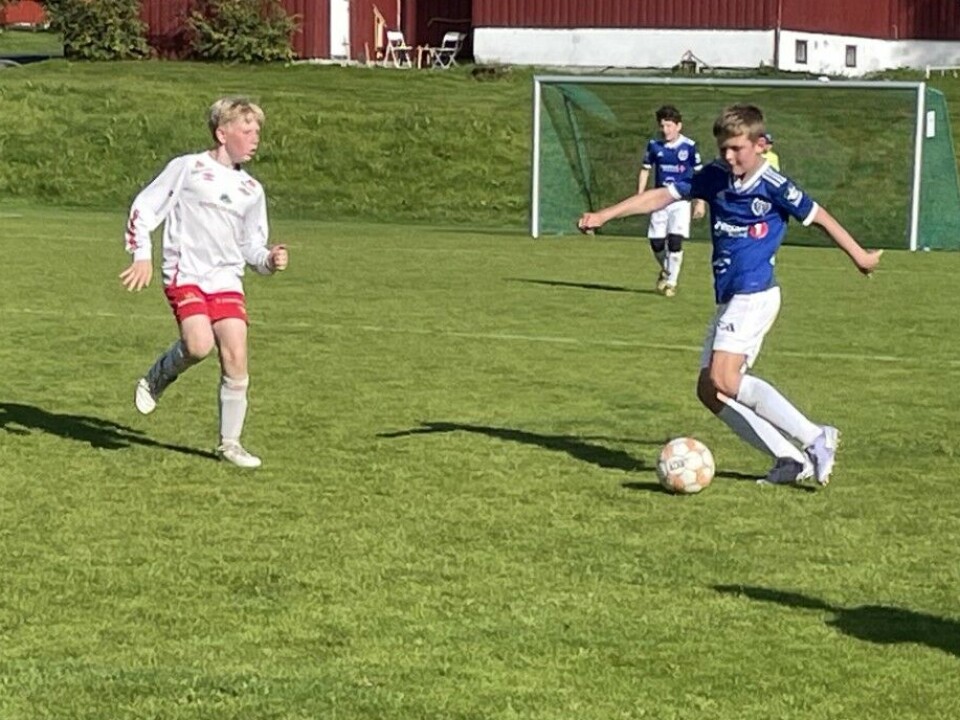 Rindalscup i strålende vær En spiller fra surnadal i blå og en fra Rindal i hvit som kjemper om ballen.