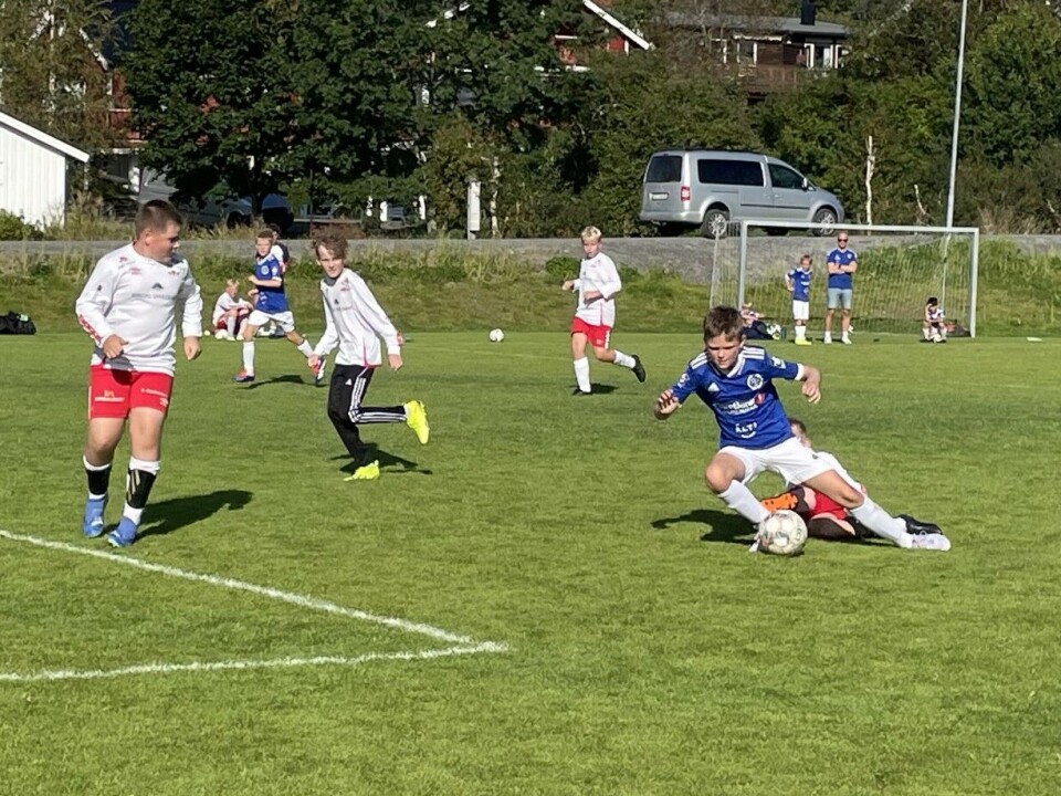 Rindalscup i strålende vær Rindal i hvit mot Surnadal i blå. De blå kjemper om å få ballen i mål og de hvite kjemper for å få stoppet de.