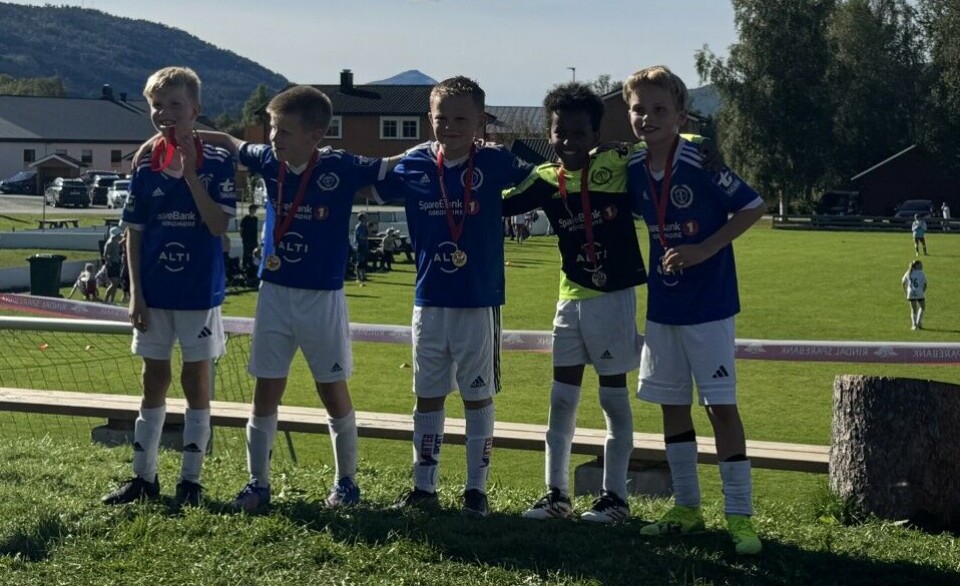 Rindalscup i strålende vær Fem gutter i blå Surnadal IL drakter smiler med medaljer rundt halsen.