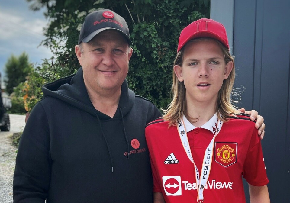 Bare forskning kan stoppe barnedemens! Støtt Demensaksjonen, oppfordrer Syver Blindheim og Jan Runar Eliassen. En godt voksen mann med veldig kort hår og caps holder armen rundt skuldrene til en en ung gutt. Gutten har langt hår og caps.