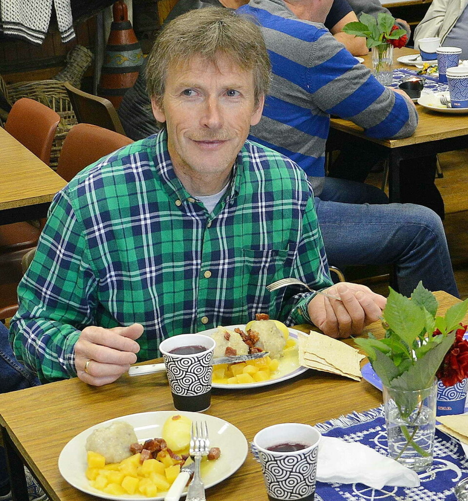 Kristian Settem er styremedlem i historielaget, søndagens ballkjørar - og stor sildballentusiast! En mann i rutete skjorte som sitter ved et bord og spiser sildball.