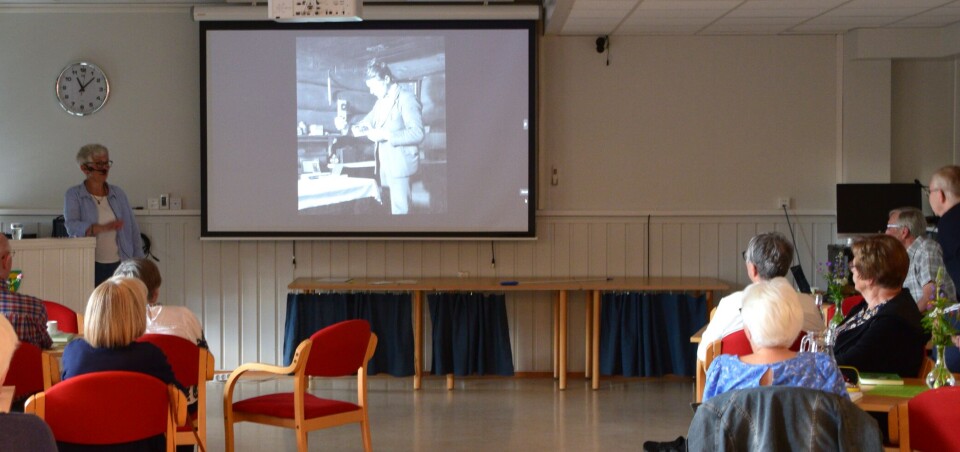 Anne Skjølsvold viste gamle bilder fra bygda. Ei dame med kort grått hår og briller, som viser bilder på lerret foran en forsamling.