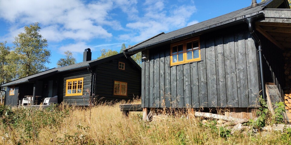Grønlisetra. Ei brunbeisa hytte i marka. Høst, sol og blå himmel.