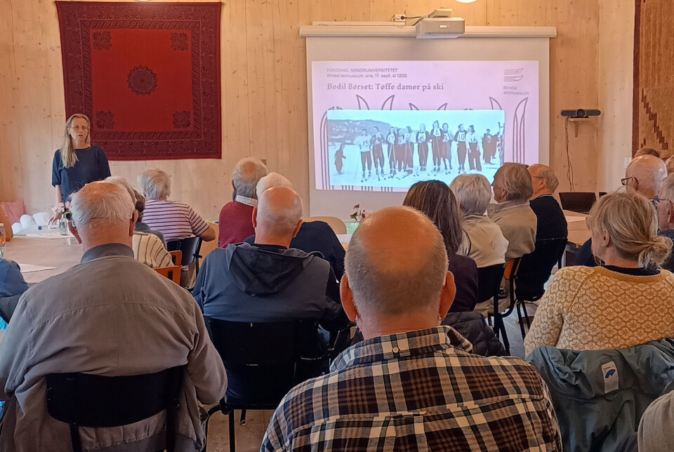 Bodil Børset framfor fullsett kafe på Rindal Skimuseum. Bodil Børset foran forsamlinga på skimuseet