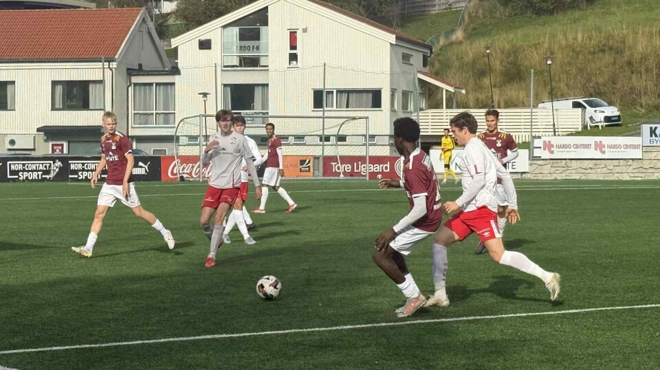 Det ble tap for Nardo 2 på Nissekollen Arena søndag Fotballspillere i hvite overdeler spiller mot spillere i vinrøde overdeler på en grønn kunstgressbane