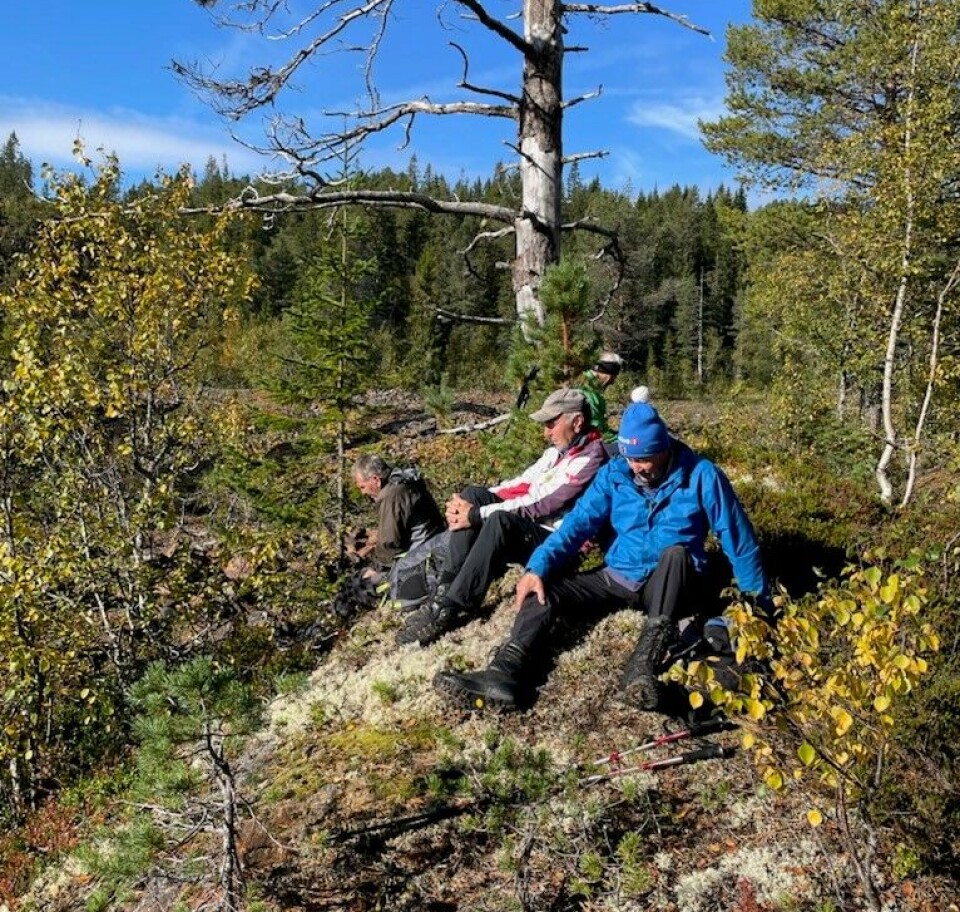 Tirsdagstur til Dragsetgruva To godt voksne menn som sitter på en kolle i skogen. Høstvær og sol.