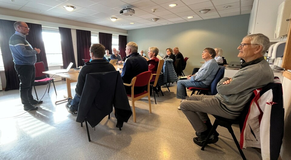 Flere representanter fra de ulike brukergruppene ved Eldresenteret møtte opp på møtet for å få med seg orienteringen. En mann som står og snakker til flere personer rundt et bord.