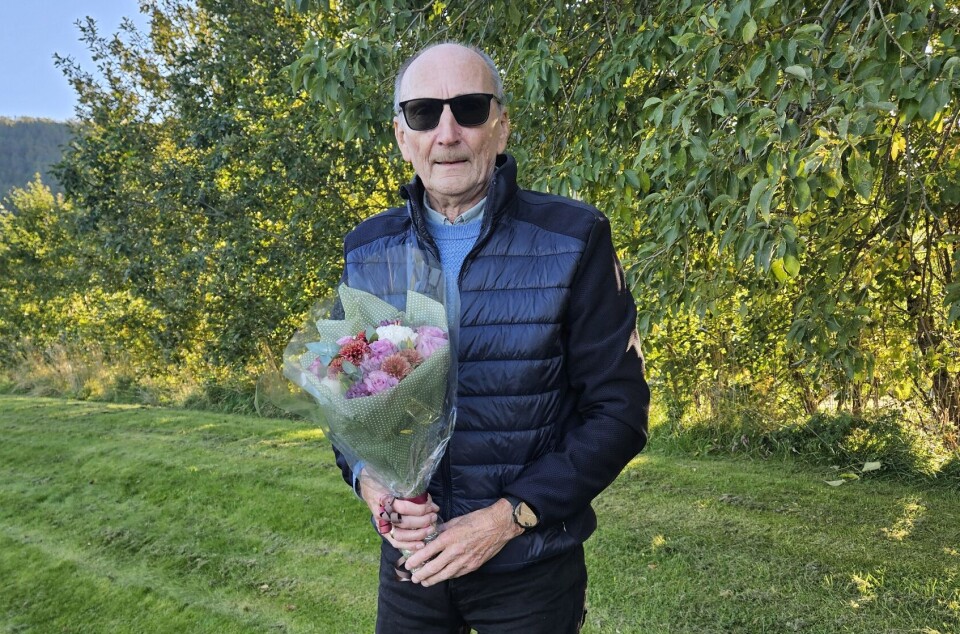 Inge Bolme er årets ildsjel i Rindal. En godt voksen mann med en bukett blomster. Høstvær og sol.