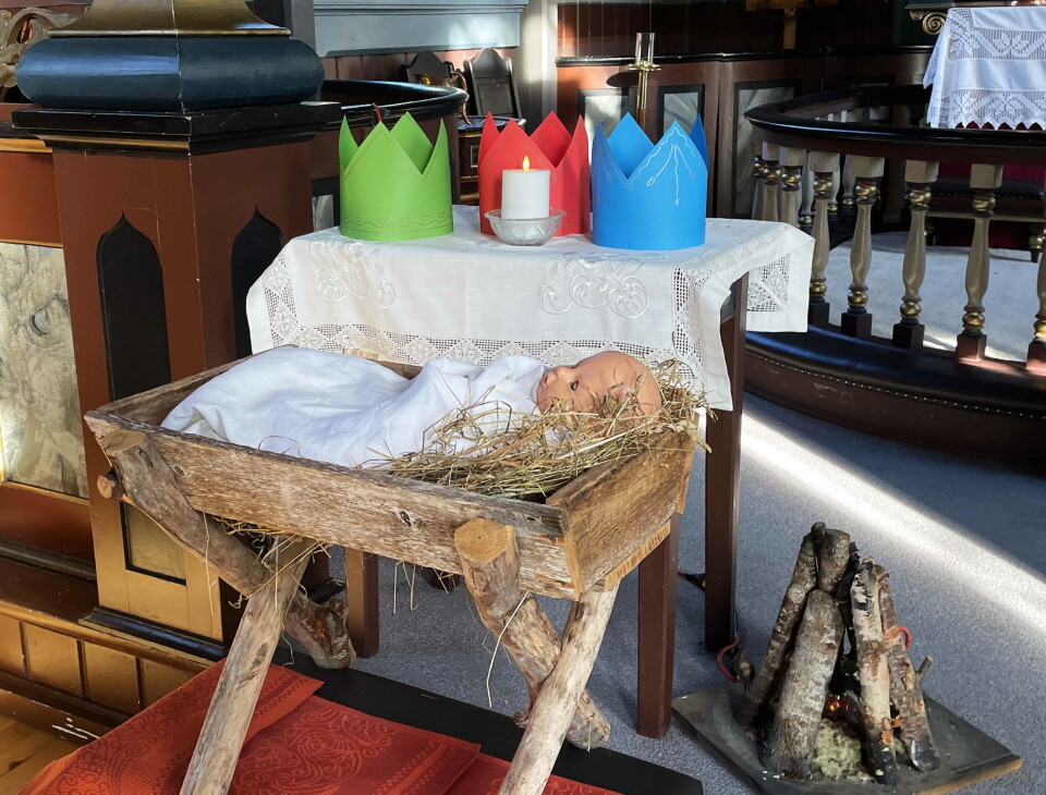 Klart for eit lite julespel. Jesusbarnet er i krybba. Hattane og bålet ventar berre på at vismennene og gjetarane kjem og tek rollene sine! Ei hjemmesnekra 'krybbe' med høy og ei babydokke oppi. Bak skimter vi alterringen i ei kirke, og et lite bord, med tre kroner av papp og en levende lys.