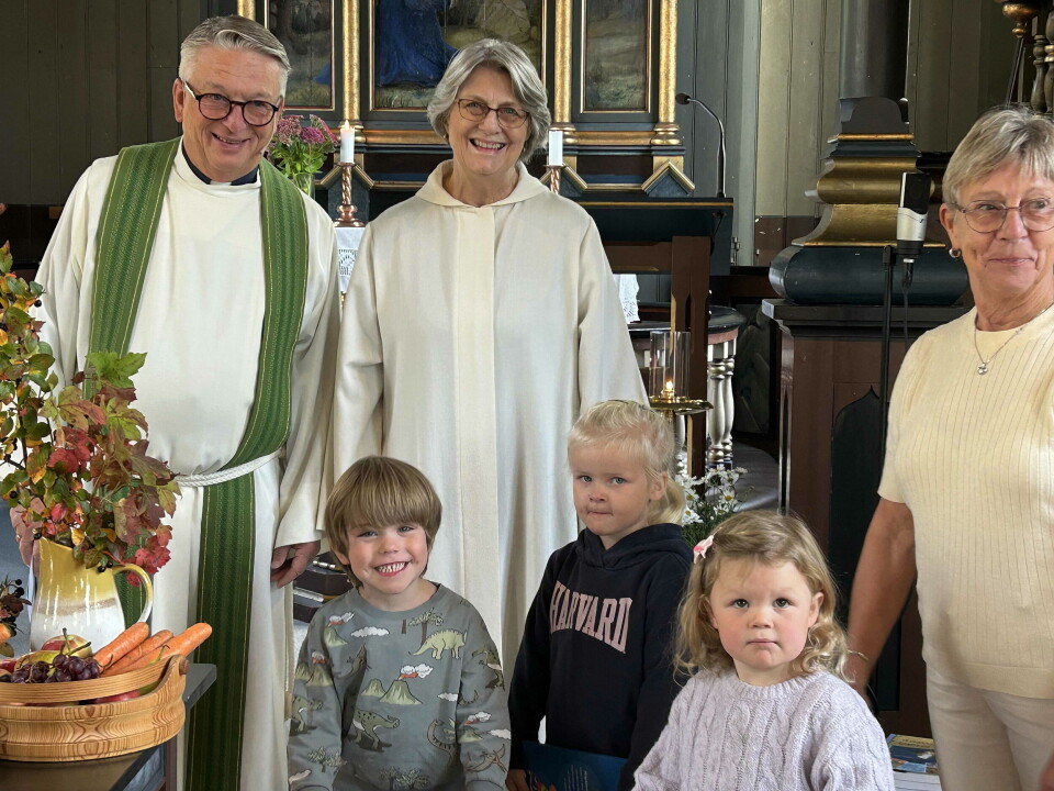 Prest Pål Arne, klokkar Randi og leiar Eva Jorid saman med dei frammøtte 4-åringane som fekk «Mi kyrkjebok». En prest og to damer, og foran dem tre små barn (4 år). De er i kirka.