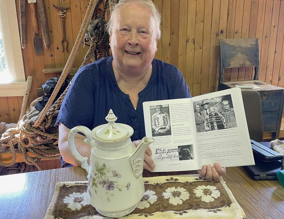 Frå Marta Havdal fekk museet kaffekanna etter «Norges eldste kvinne» i si tid – Guro Grøtan (1849-1955). Ei smilende dame med grått hår som sitter ved et bord med ei stor flott gammel kaffekanne foran seg, mens ho holder fram ei bok med svart/hvitt-bilder.