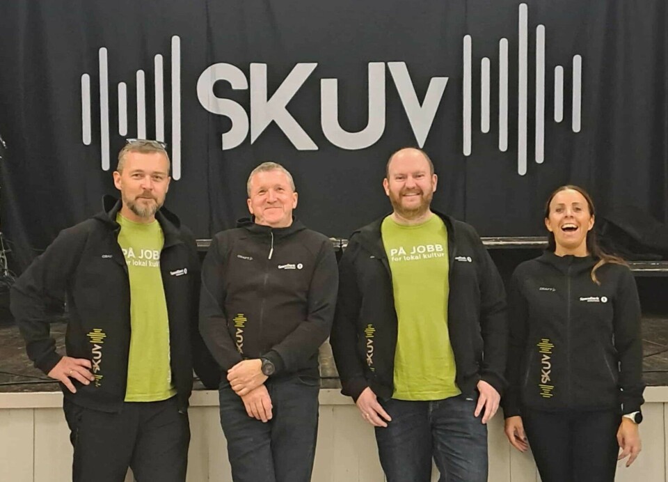 Styret i SKUV består av: (f.v.) Håvard Stensønes, Jense Indergård, Øystein Hjelle Bondhus og Øyunn Aune. fire personer i sort og grønt foran scene som det står SKUV på