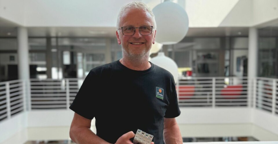 Anders Betten, S-Nett. En mann med grått hår og briller, med el-sikringer i hendene.
