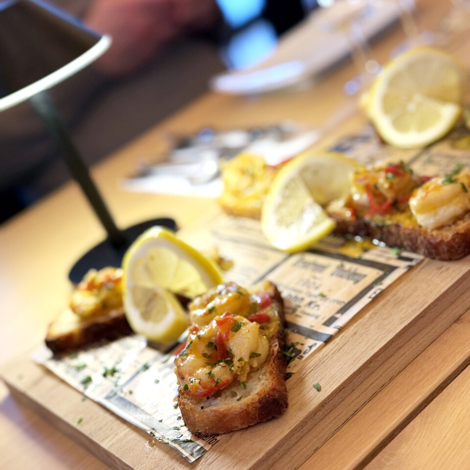 Scampi forrett til ølsmaking. Små forretter av scampi på brød på et bord.