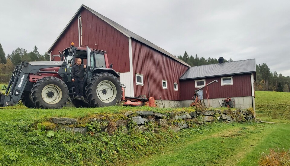 Frode Storås Fosseide er valgt ut som en av ti finalister i Landbrukets bærekraftspris. En mann som står i stigtrinnet på en traktor foran et fjøs. På tunet er det grønt gress, og himmelen er overskyet.