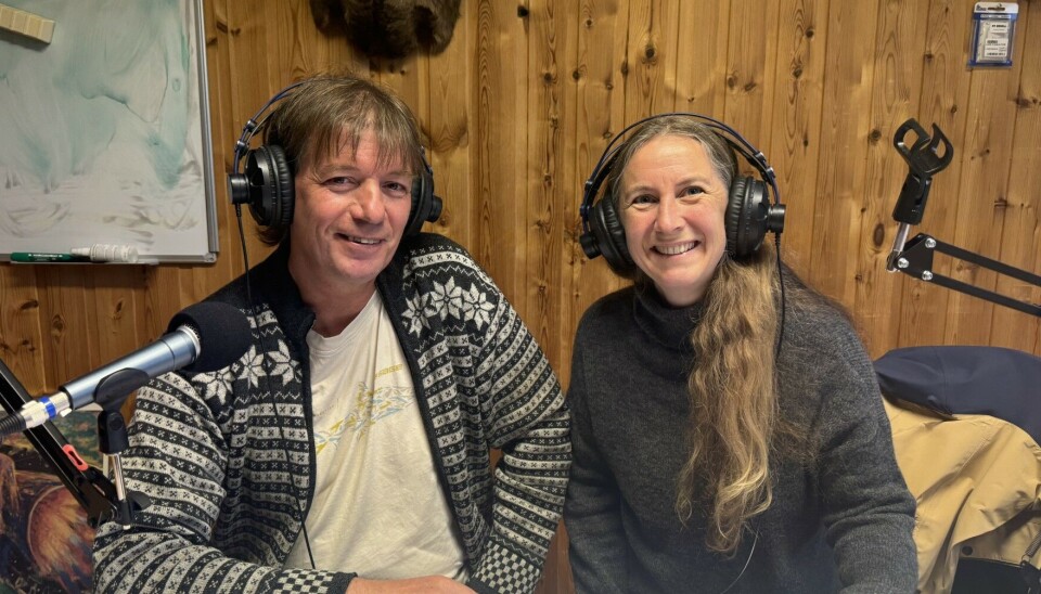 Forfatter og 'alt-mulig-mann' Svein Sæter sammen med podkastvert Gunn Elin Røen. En mann i strikkekofte og kort, stritt hår og en dame i høyhalset genser og langt, bølgete hår sitter med headset og smiler mot fotografen.